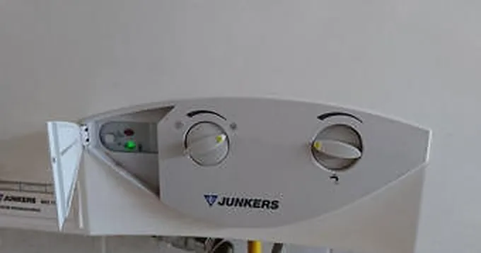 Mano bajo el chorro de una regadera comprobando la temperatura del agua
