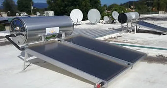 Mano bajo la regadera comprobando agua tibia en una casa con equipo solar en el techo